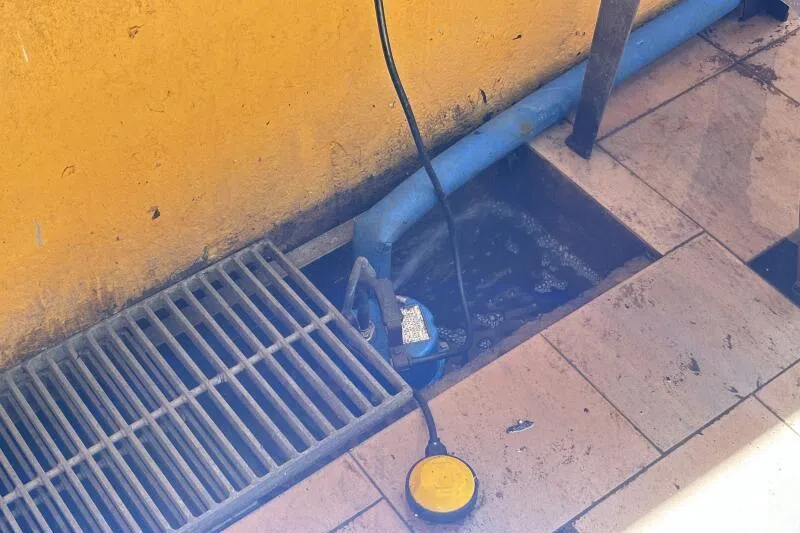 记者走访现场时，工作人员正在用抽水机清理污水。（曾美玲摄）