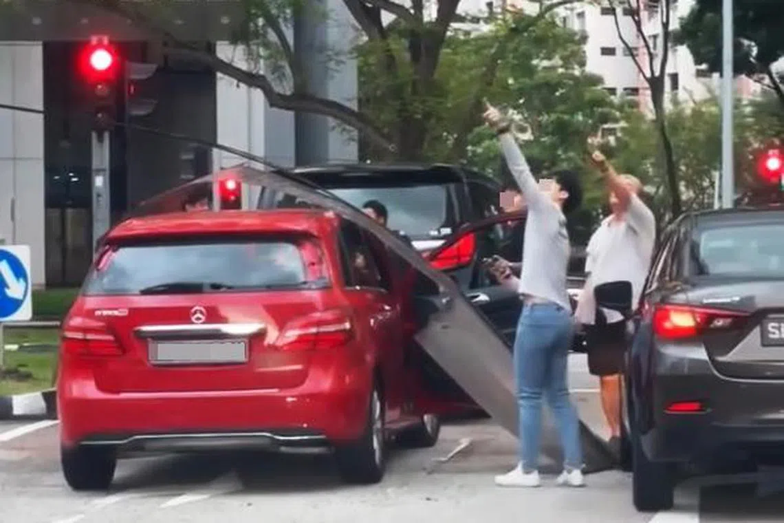 事发后，两名男子指着上方，相信在找着掉落的遮雨盖是从哪一座公寓飞落下来。（取自脸书）