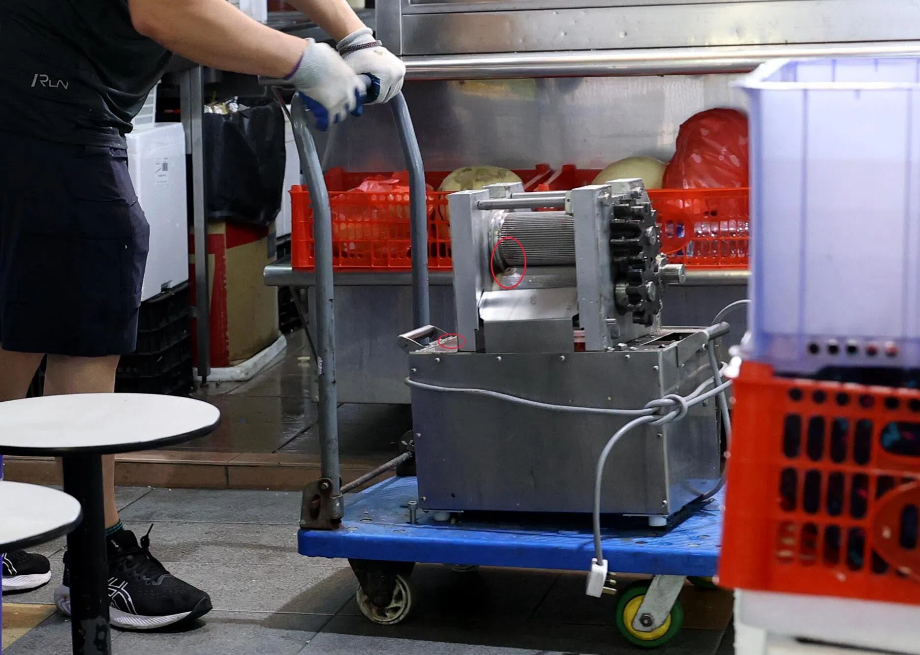 一名男子推着涉事的甘蔗机离开，上面疑留有血迹。（庄耿闻摄）