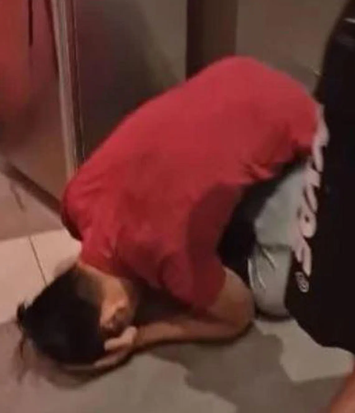 嫌犯被捕后掩着脸跪在地上。（互联网）