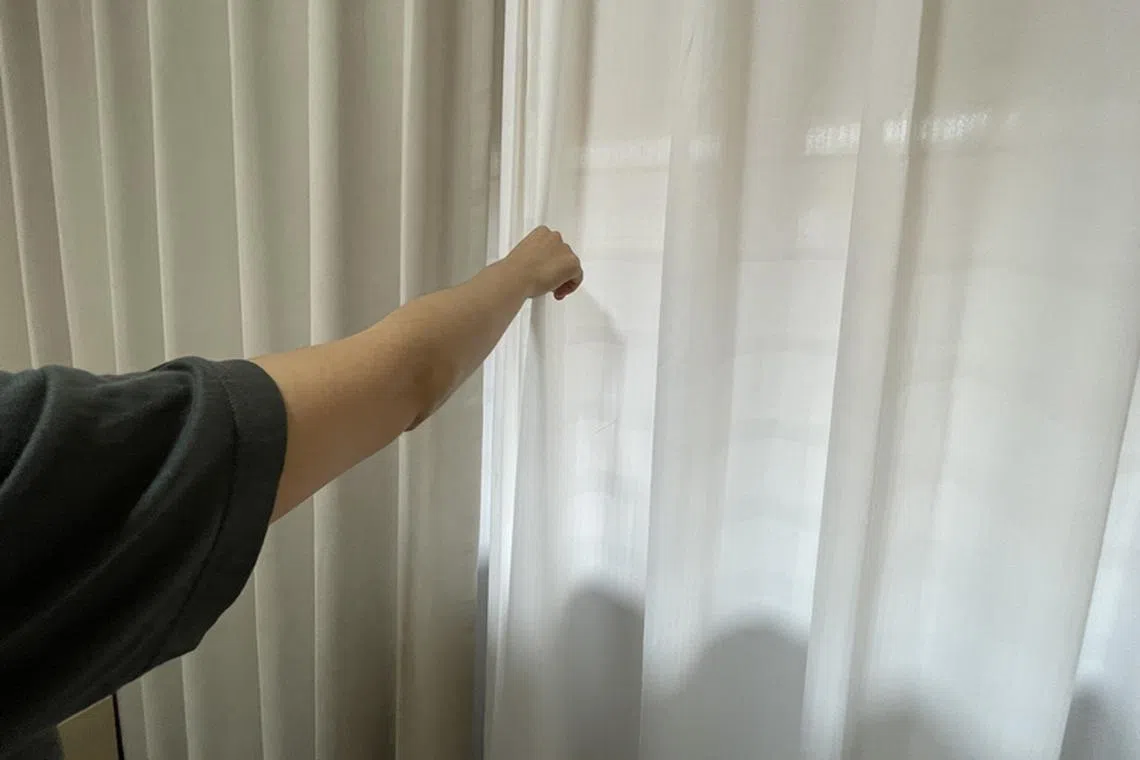 居民郑惠忆说，有时得来到靠近窗口的地方才有手机信号。（冯凯麟摄）