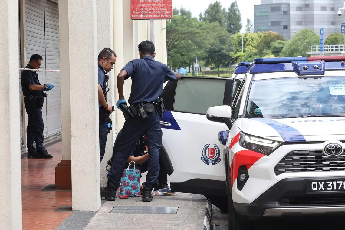 警方翻查金发男的背包和随身携带的物品。（吴伟国摄）