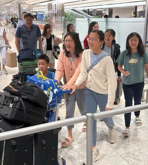 黄明俊一家推着行李走出机场时眼中充满喜悦。（纪允贤摄）