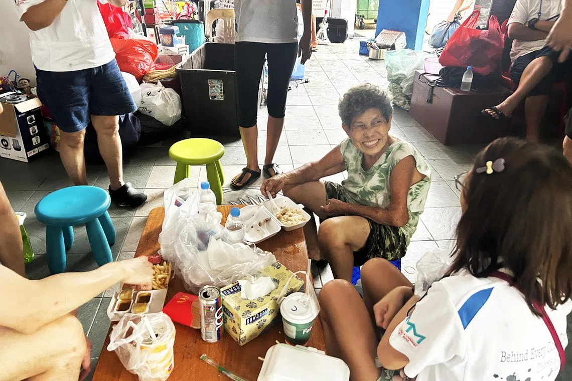 每天风雨不改捡纸皮养活一家的78岁老妇欧亚杨，与义工们一起用餐 。（严思莹摄）
