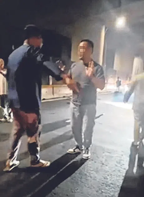 肇事司机下车后，热心公众要求他坐在路旁等警察来。（读者提供）