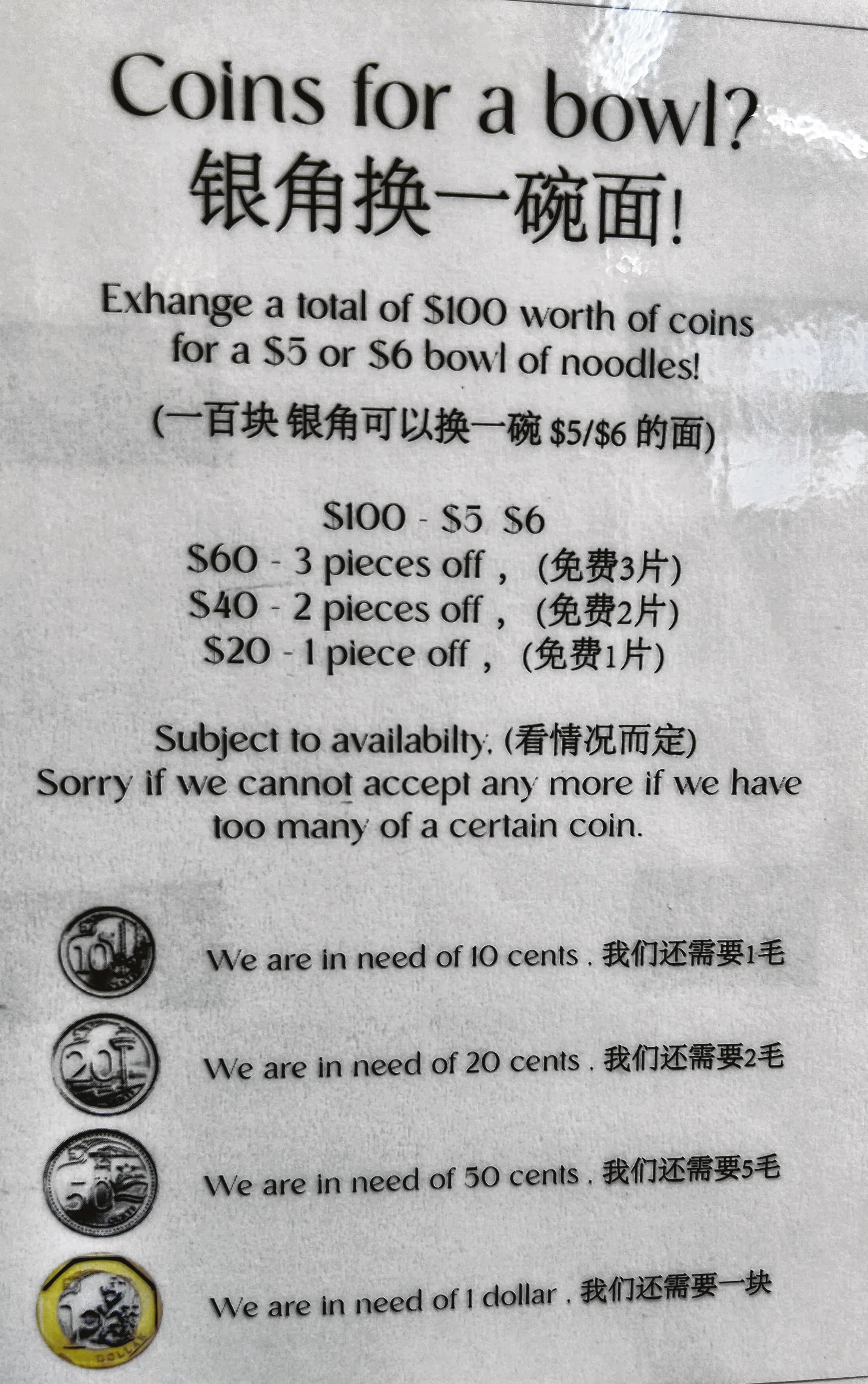 摊位贴着告示指，兑换100元硬币能换取一碗价值5元或6元的面。（曾美玲摄）