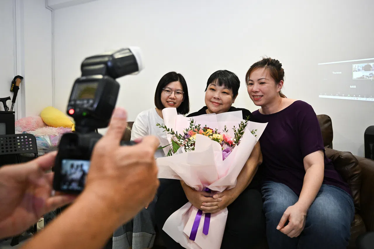 好友在“生前葬礼”上跟卡罗琳（中）合影。（海峡时报）