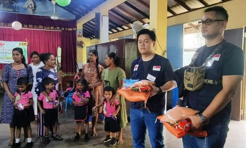 纳迪姆（右一）与新加坡红十字会的义工，为斯里兰卡的学生分发食物。（取自纳迪姆IG）