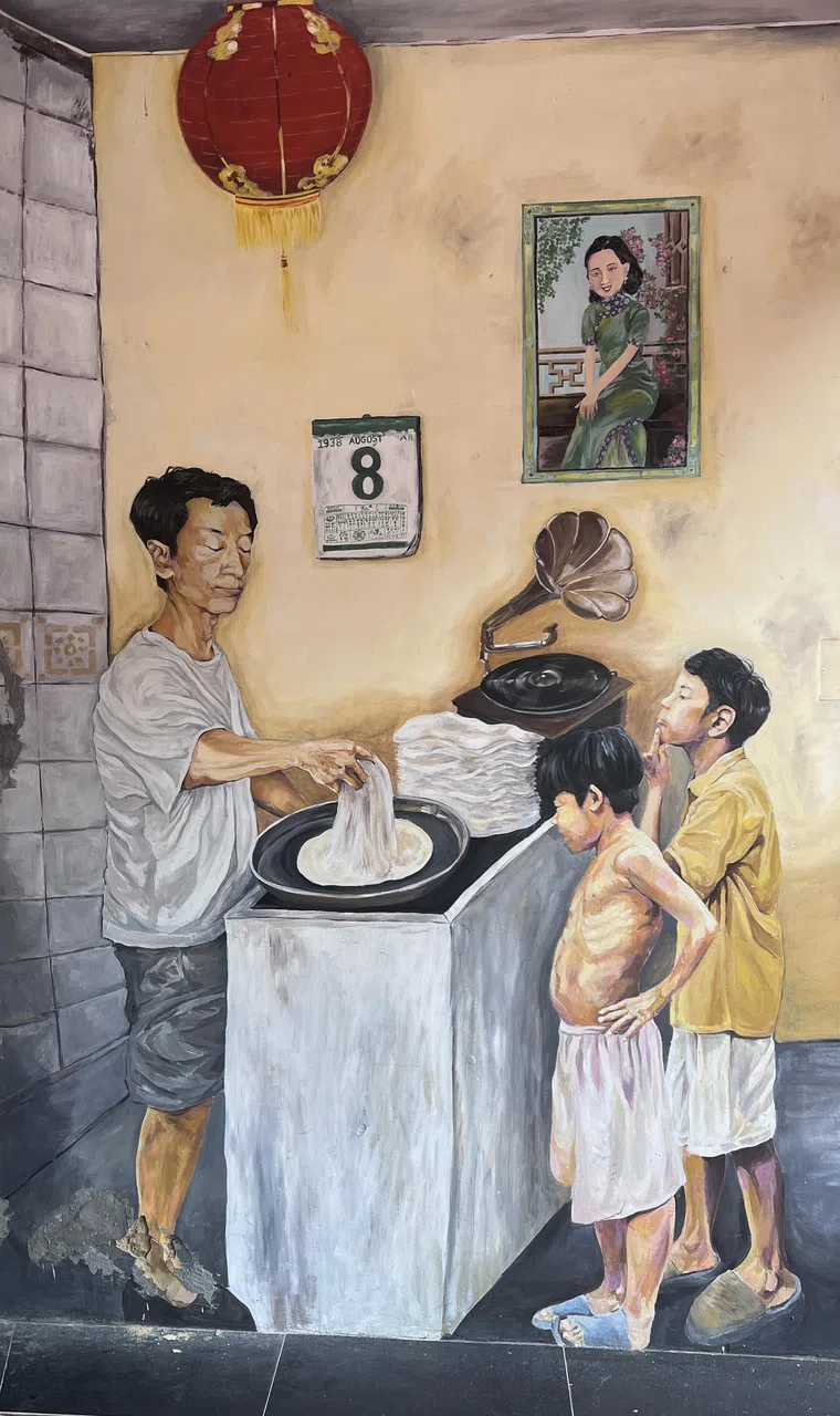 店外有一幅壁画是以郭吉祥为原型的薄饼师傅在孩童面前制作薄饼。（管雅凡摄）