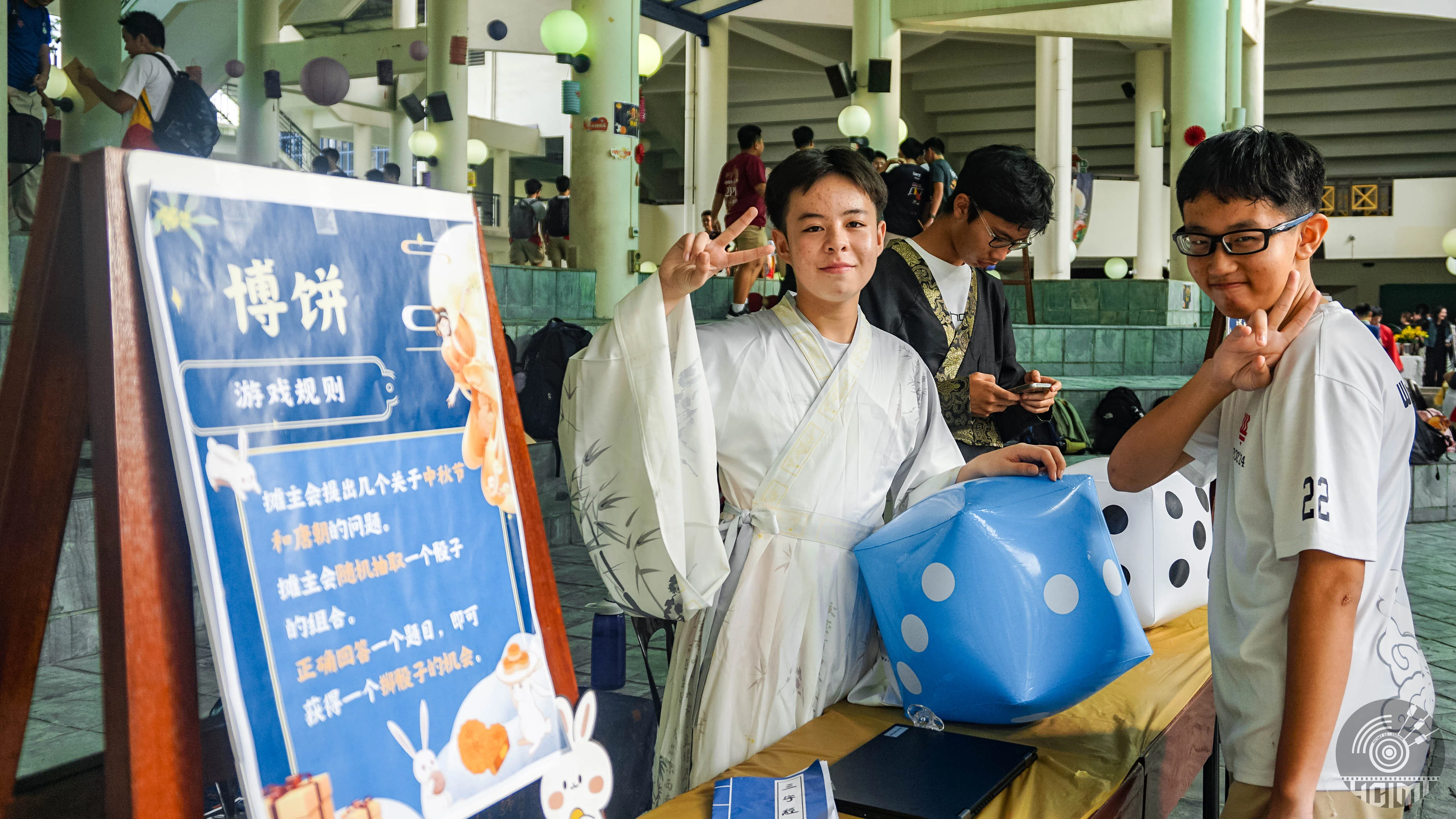 仿古游戏之一博饼摊位，学生负责人给参与者介绍游戏的玩法，并带领他们一起玩。（华侨中学邱亮岷摄）