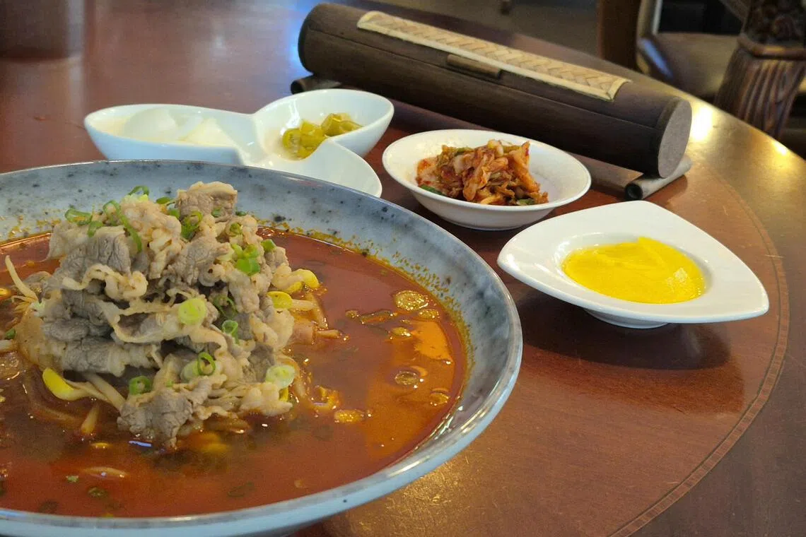 牛肉辣面搭配腌制小菜，口感丰富。（陈爱薇摄）