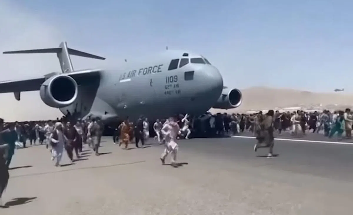 阿富汗人周一涌入喀布尔机场停机坪和跑道，希望能搭上各国撤侨的班机。飞机已经在滑行准备起飞，美军士兵向空中开枪警告，许多赶不上飞机的民众四下逃跑。（互联网）