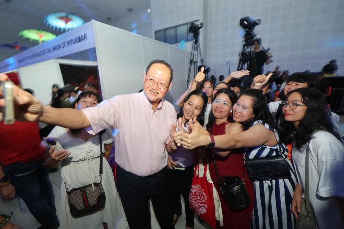 人力部长陈诗龙医生（左二拿手机者）与外籍帮佣合照留念。（唐家鸿摄）