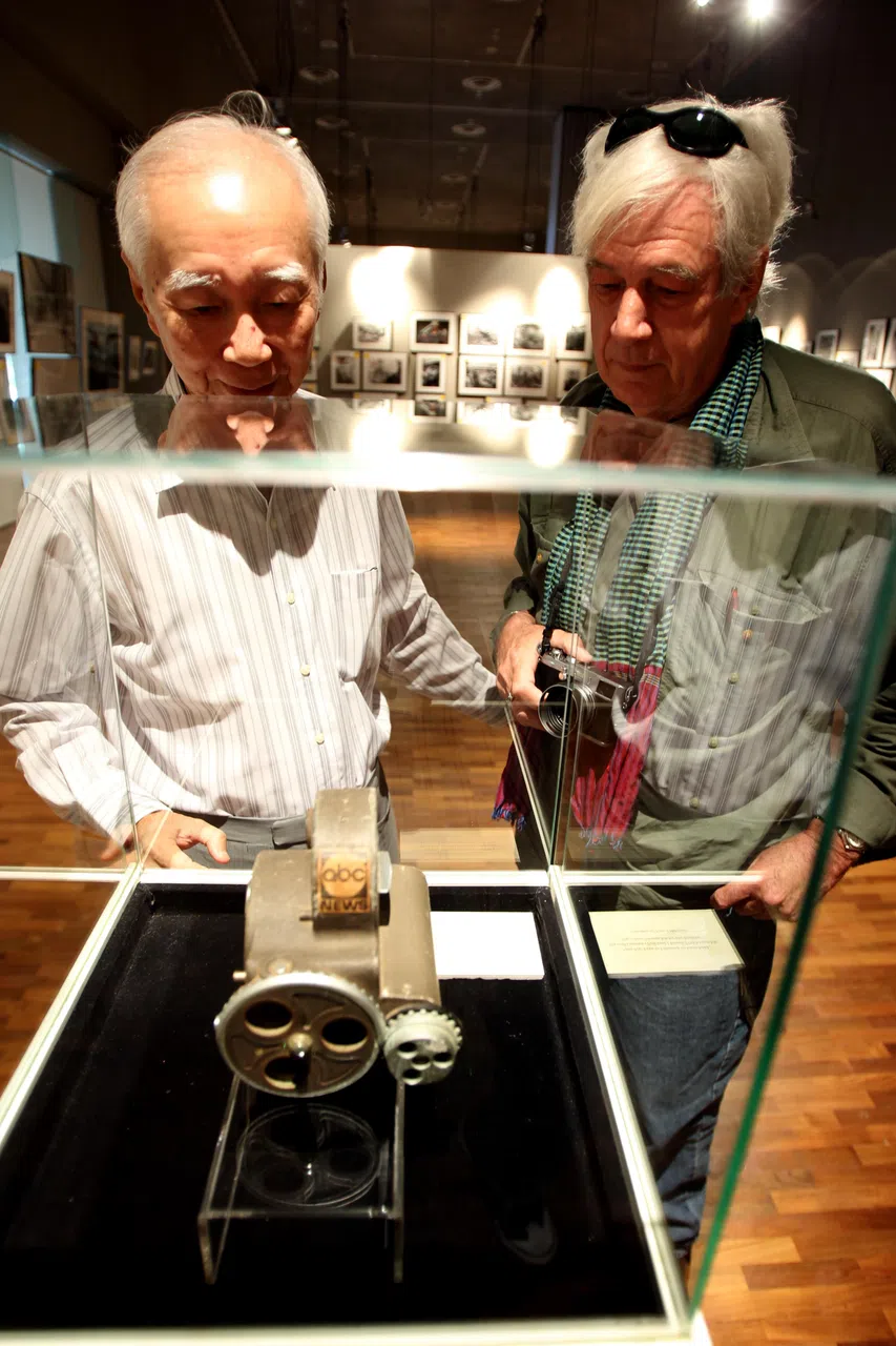 陈加昌（左）和两度获得美国普利策摄影奖的提姆·佩兹（Tim Page），2011年参观越战摄影展时，在岑启辉1972年7月遗留于南越广治省战场的摄影机残部前缅怀故人。（档案照片）