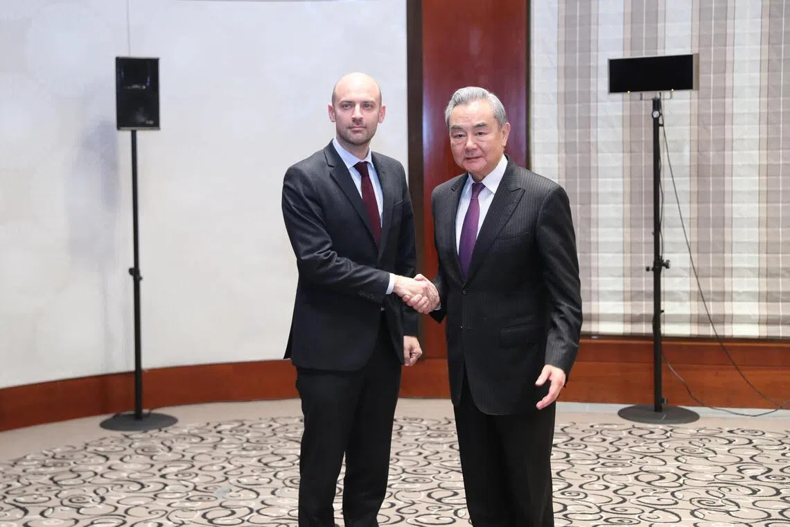 中共政治局委员、中国外交部长王毅（右）星期五（2月13日）在出席慕尼黑安全会议期间，会见法国外长巴罗。（新华社）