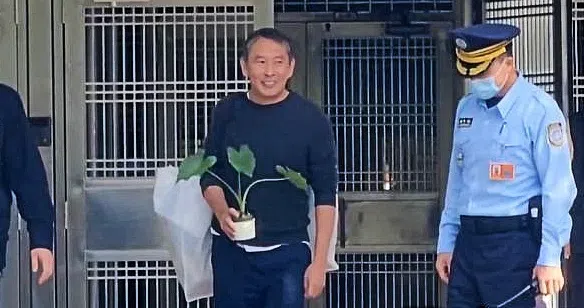 导演钮承泽（右二）23日上午获释，手上抱着亲手栽种的芋头苗盆栽，象征“出芋”、幼苗则代表“新生”（互联网）