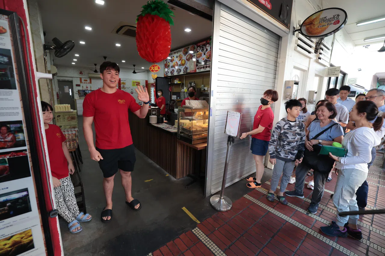 在墨士廉（左二）拉开门帘前，店前就已经排起队伍。（梁麒麟摄）