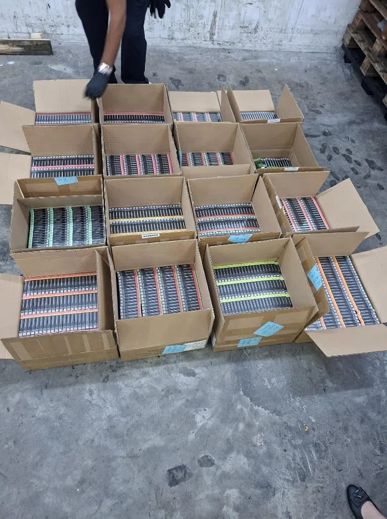 一盒盒电子烟弹藏在纸箱，然后混入被申报为充电宝的货物中，但被移民局人员识破。（移民与关卡局提供）