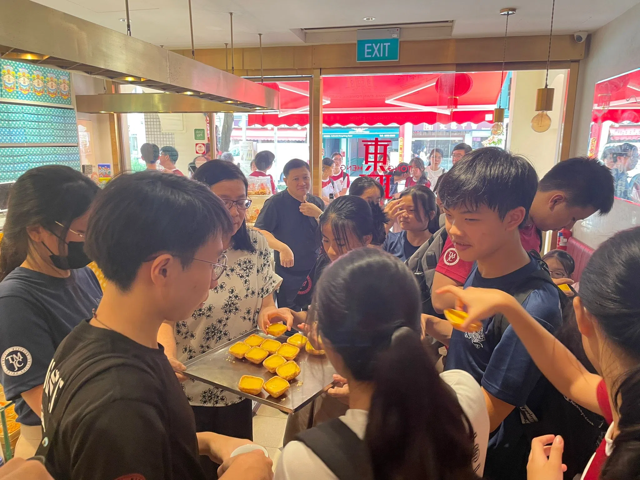 学生品尝东兴饼家的古早菱形蛋挞。（淡滨尼美廉初级学院提供）