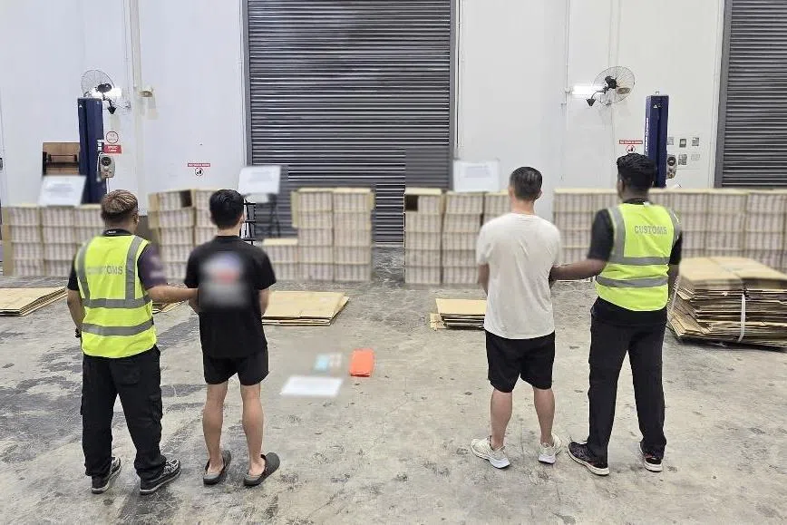 关税局在两天执法行动中逮捕三名涉案男子，图为其中两名落网男子。 （新加坡关税局提供）