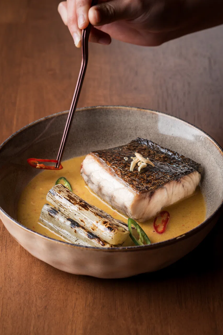 香料椰汁烤鱼的酱汁加入多种香料和香草、椰浆与江鱼仔焖煮。（餐馆提供）
