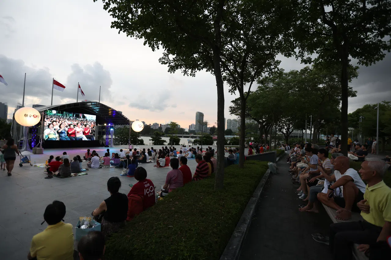 许多没能索到入场券的公众，在河滨走道观看现场转播，一起感受热闹气氛。（关俊威摄）