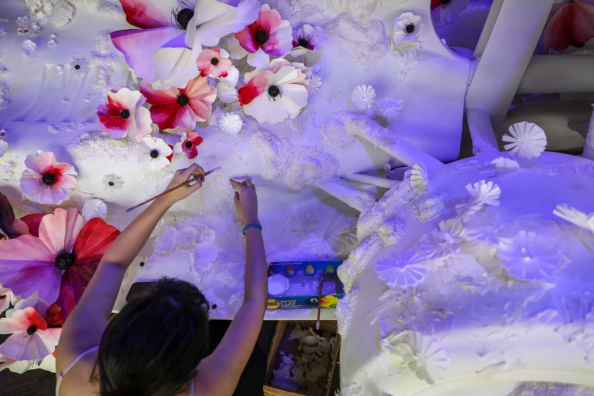 制作长达2000小时，许恒梅的九人团队细心雕琢出车身上的青苔纹理，还有水彩上色的罂粟纸花。（林泽锐／摄）