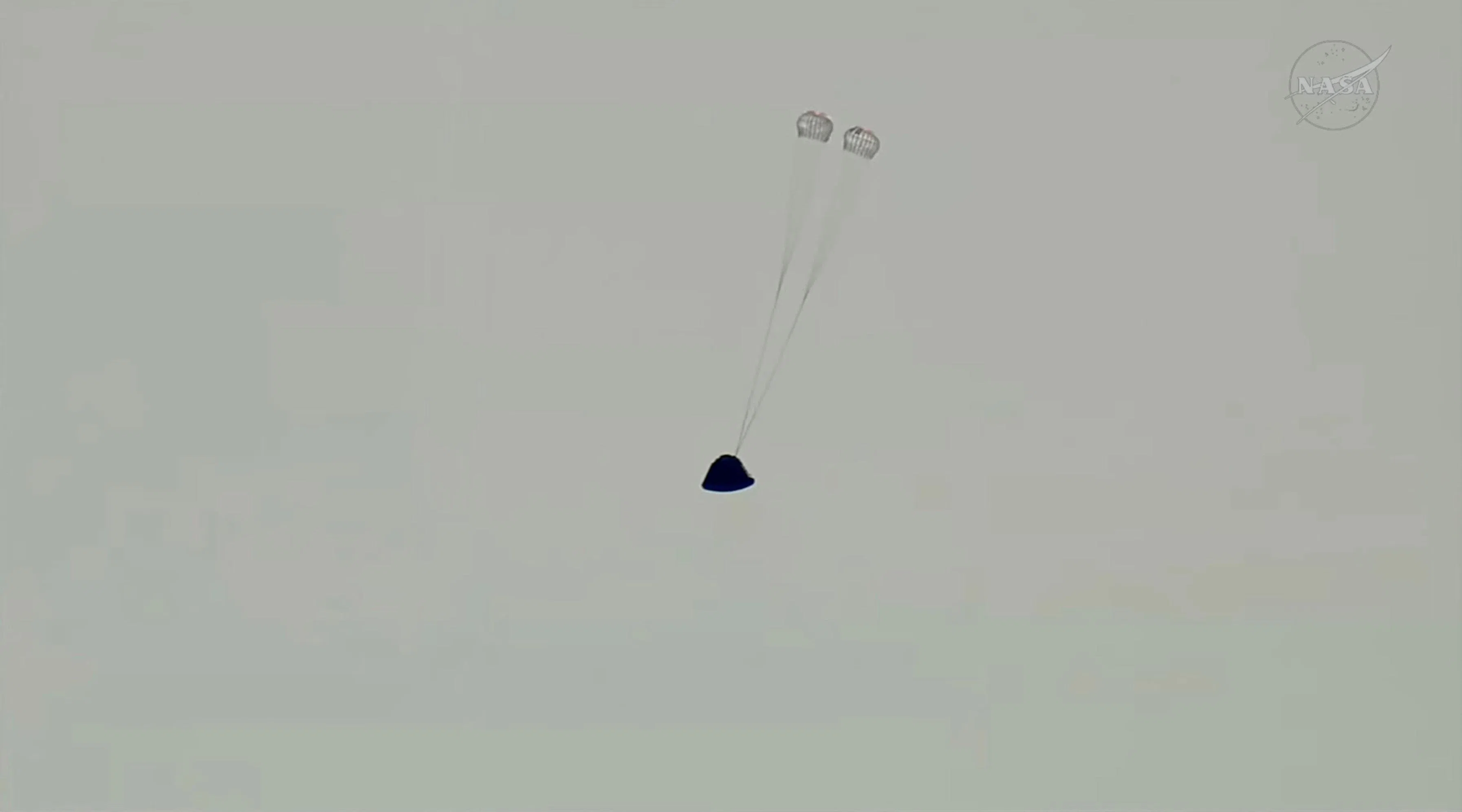 返回舱的第一组降落伞打开，这一组减速伞主要确保返回舱稳定和减速。（路透社）