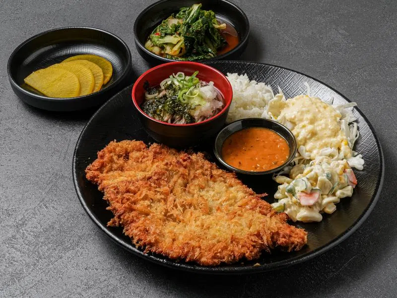 炸猪排外酥内嫩，搭配每日熬制的酱汁与白米饭享用。（餐馆提供）