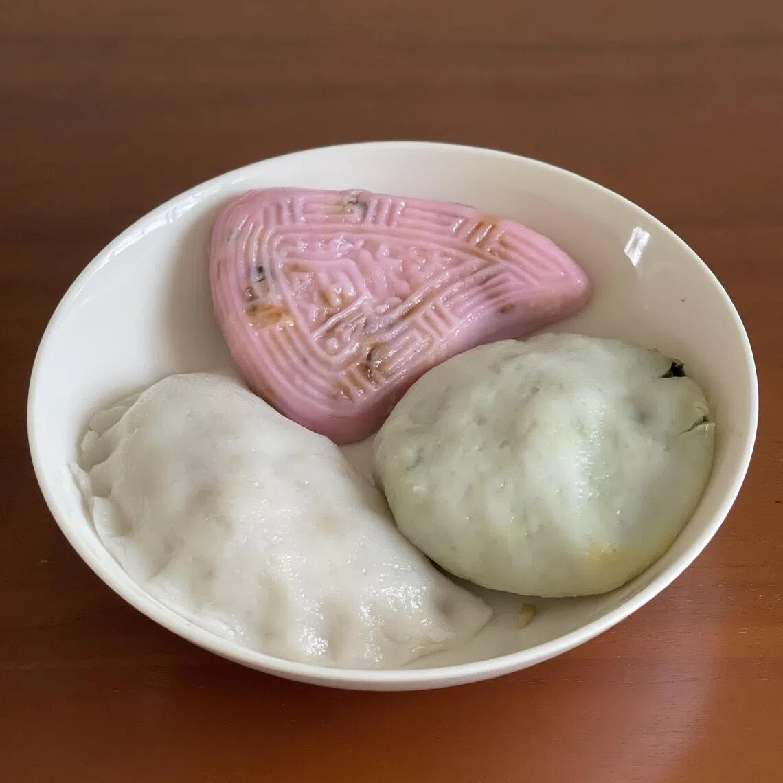 淡粉红色的传统饭粿（顺时钟）、韭菜粿和笋粿，手工制作还原经典味道。（黄靖晶摄）