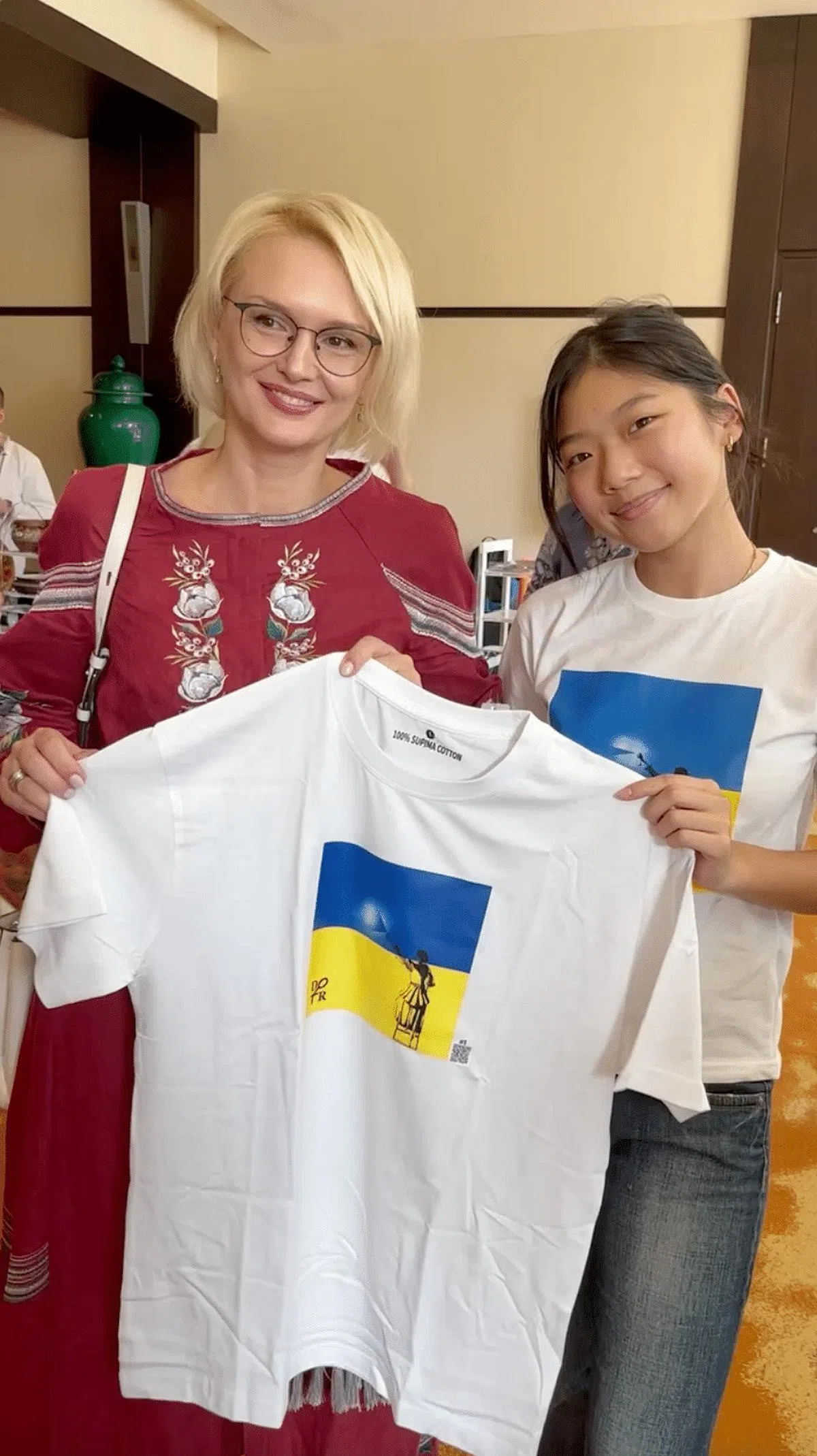 苏郁心（右）5月底托乌克兰驻新加坡大使泽连科把自己设计的两件（一黑一白）衣服转交给乌克兰总统泽连斯基。（受访者提供）