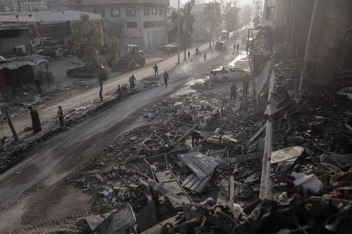 11月20日，加沙城一处社区遭以色列空袭，民众事后查看破坏情况。（彭博社）