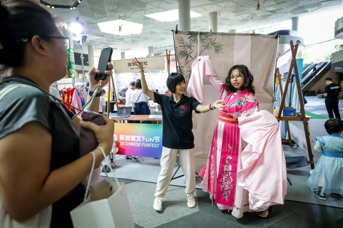 公众可在“慕容汉服”摊位体验汉服换装，穿越古今拍照留念；在南华潮剧社摊位试穿戏曲服装、学习基本身段动作，近距离接触传统戏曲艺术。（叶振忠摄）