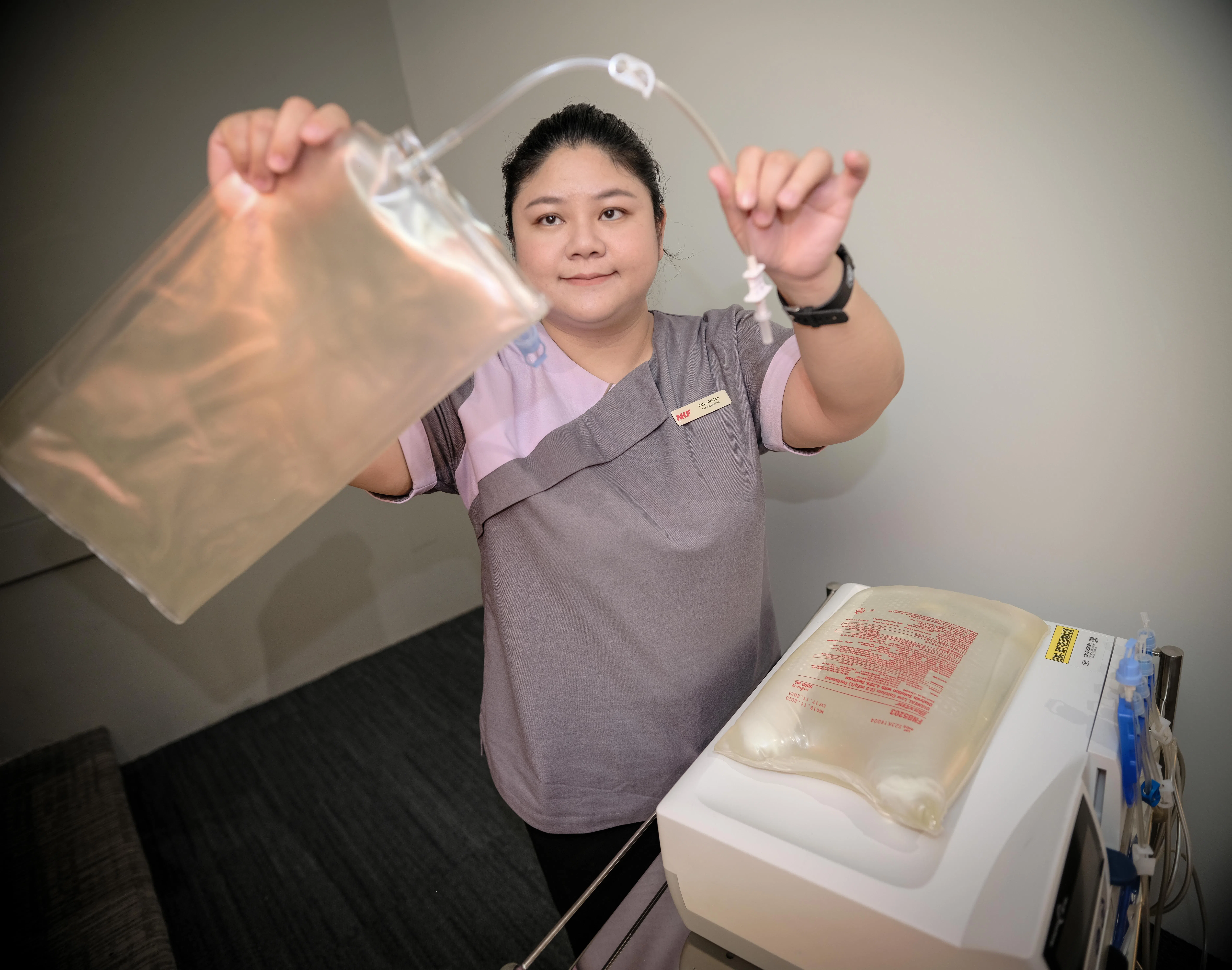 NKF腹膜透析护士组长冯玉珊，向记者演示病患在家进行腹膜透析的准备工作。（曾坤顺摄）