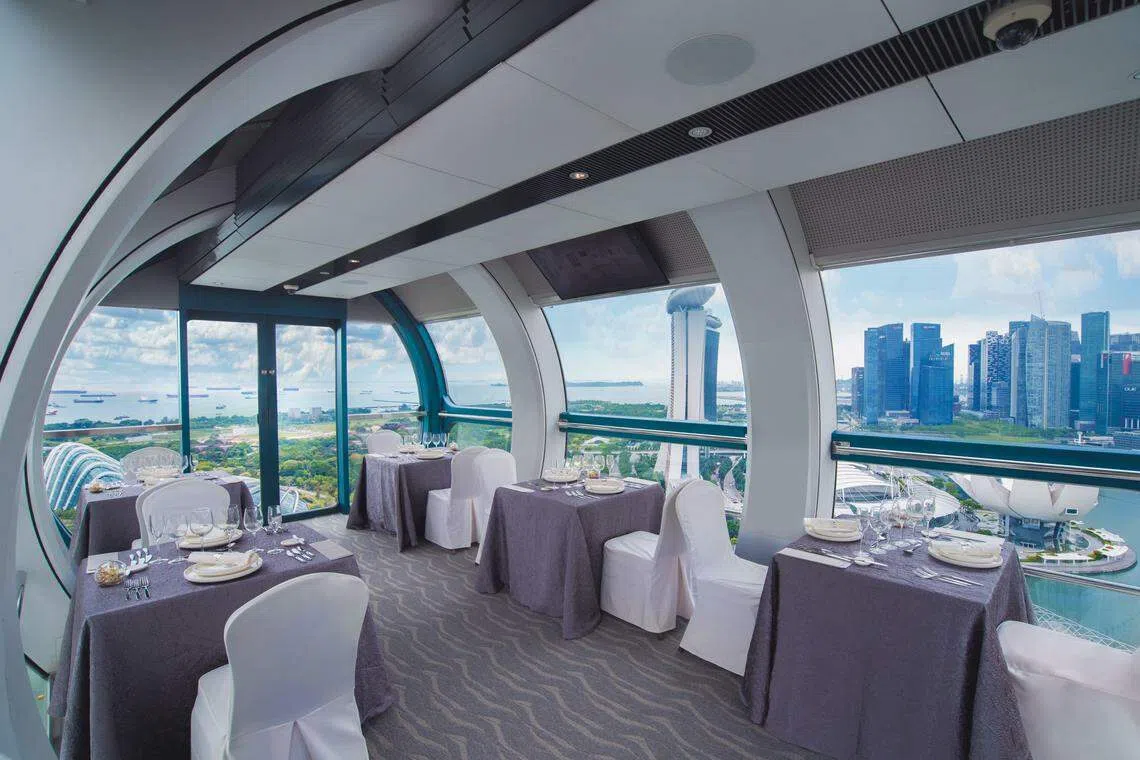 共享观景舱布置得像餐馆，加上美景一览无遗，食物更美味。（新加坡摩天观景轮提供）