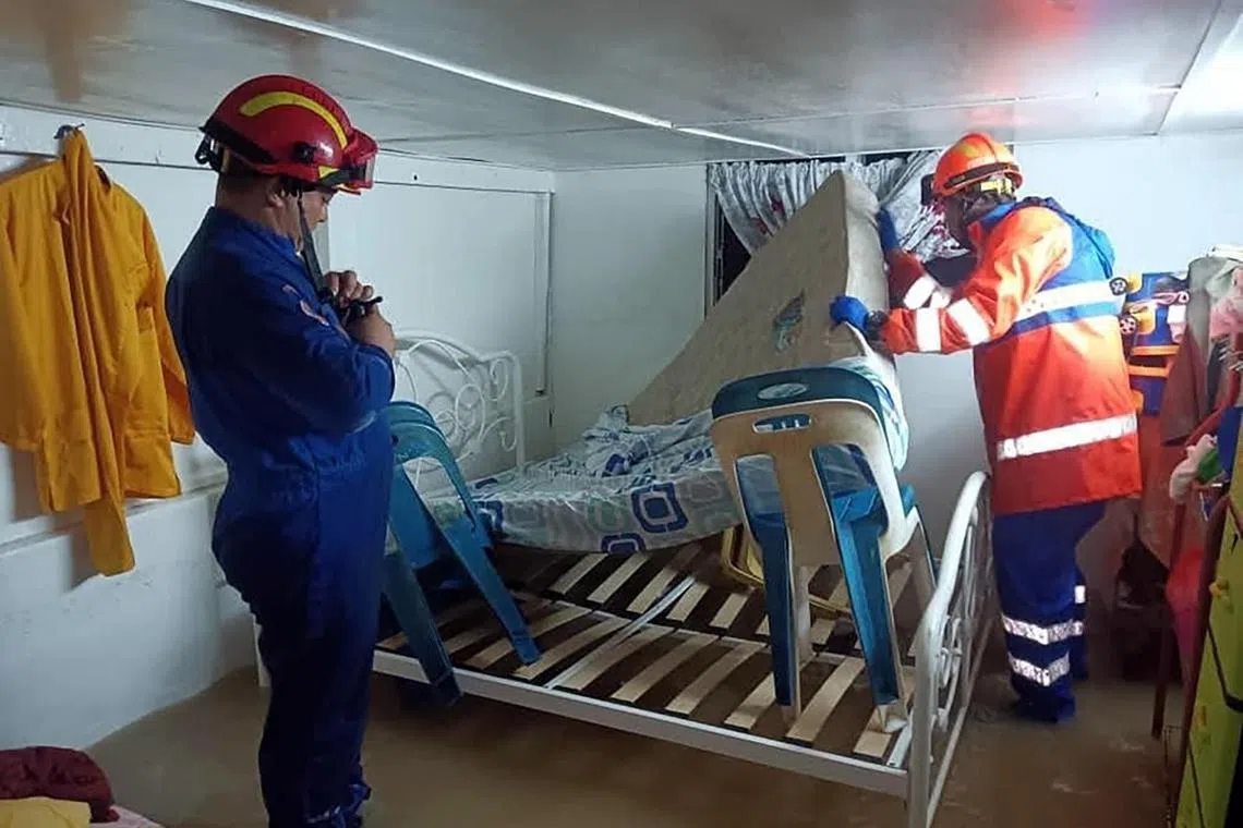 民防部队人员帮忙把灾民的家具、床褥等移到屋内较高的地方，避免被水浸泡损坏。（取自槟城民防部队脸书）