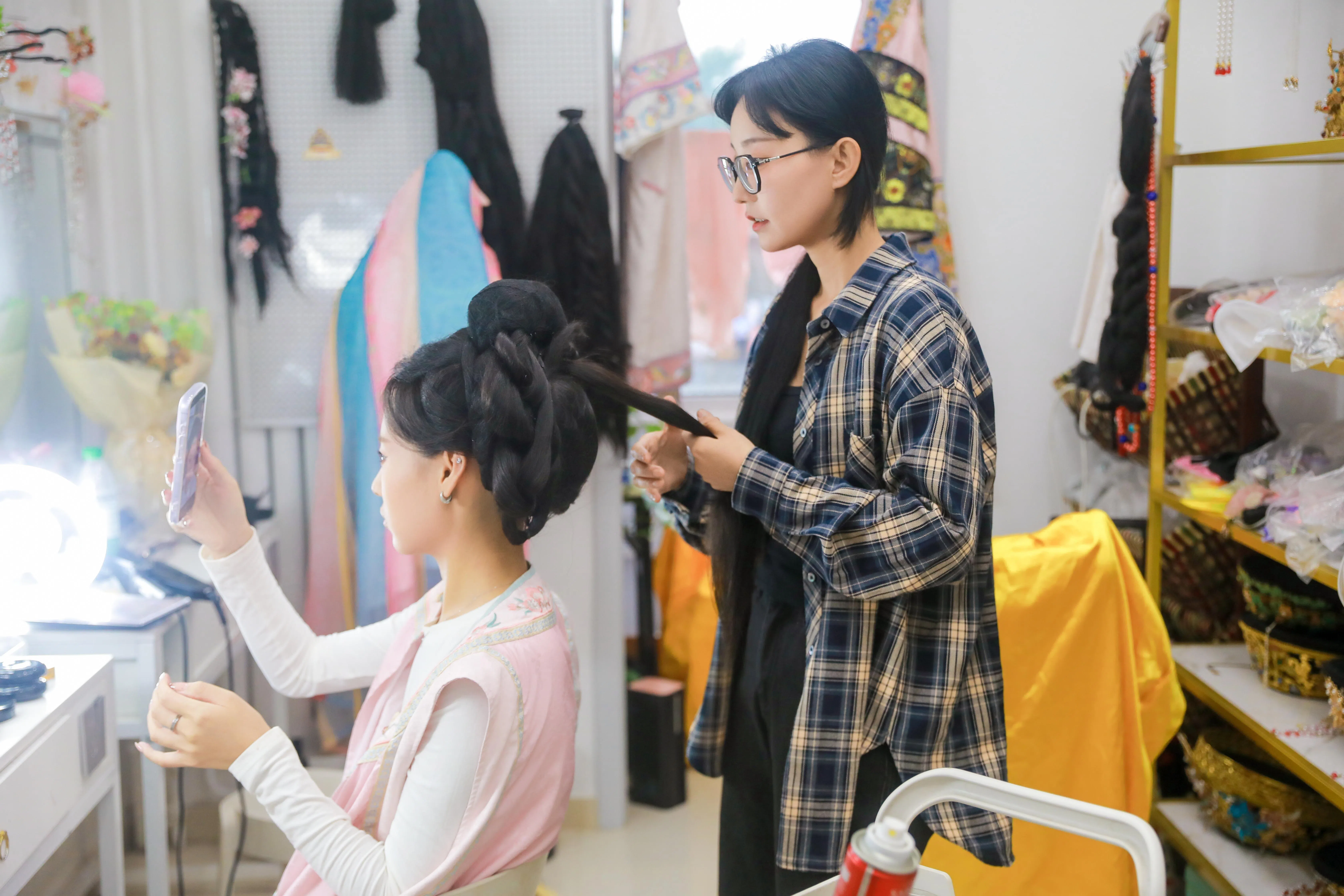 北漂妆造师任晓彤在为客户做妆造。因为有一技之长，她自称没有太大职业焦虑。（受访者提供）