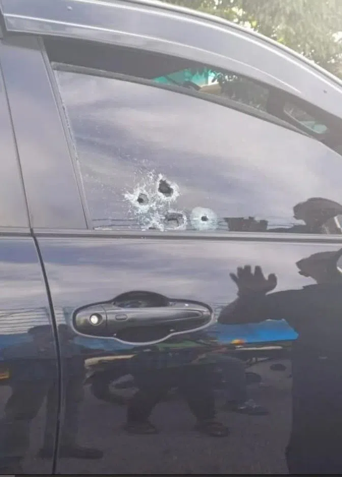 枪手开枪后，货卡司机座玻璃窗出现五个弹孔。（光明日报）