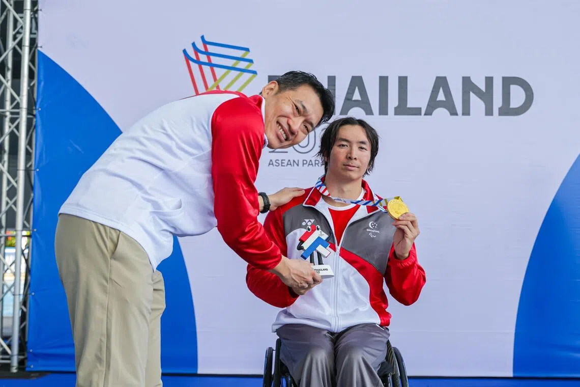 杜维崧在男子100米自由泳S7级项目中成功卫冕，文化、社区及青年部代部长梁振伟将金牌颁给他。（新加坡全国残奥理事会提供）