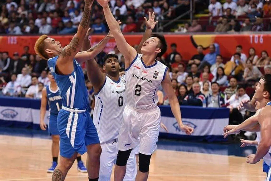 在2019年的菲律宾东南亚运动会上，刘主光（2号）在新加坡对垒菲律宾的篮球赛中积极拼抢。（受访者提供）