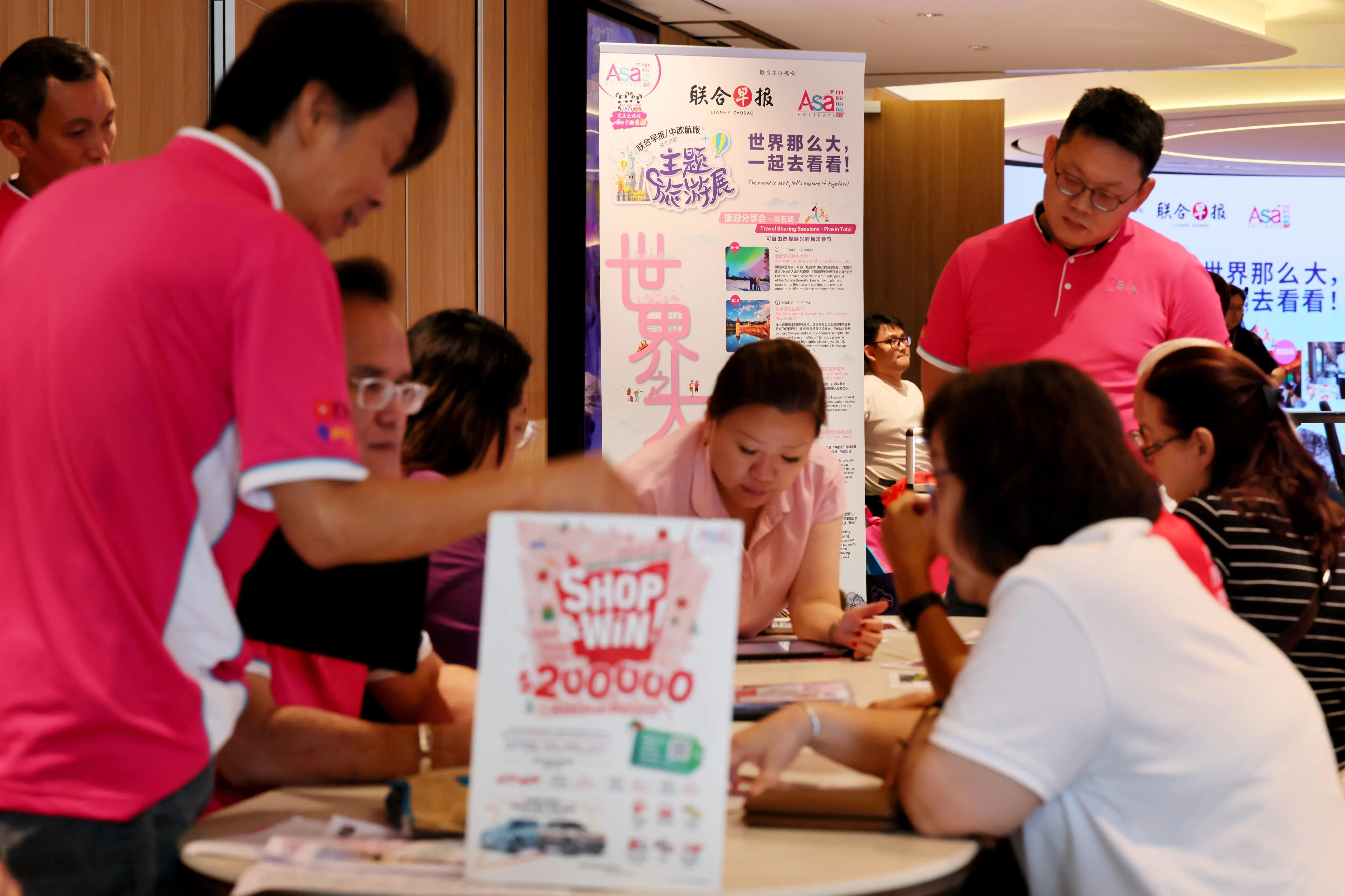 出席者在礼堂外积极咨询旅游配套以及行程规划细节。（龙国雄摄）