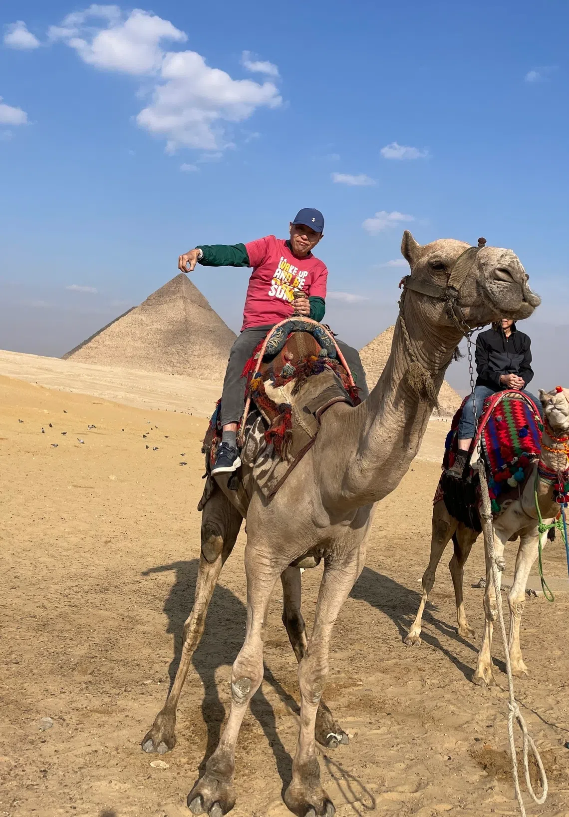 我们骑着骆驼绕行金字塔群。（王华儿摄）