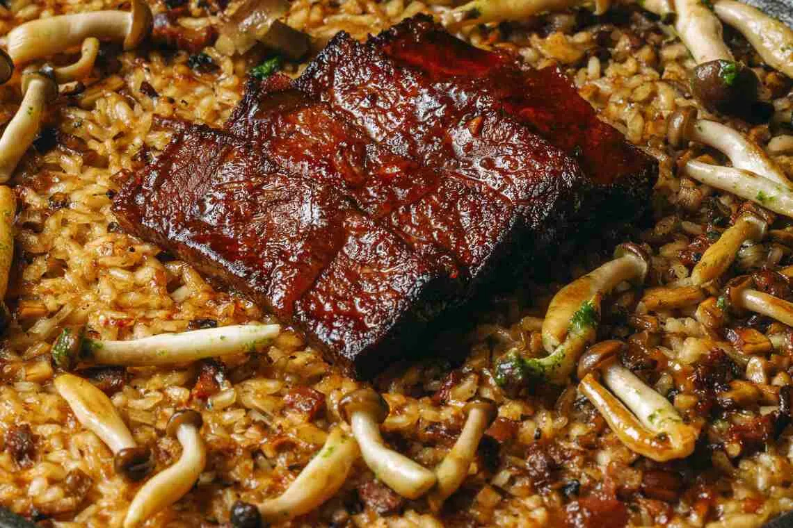 和牛肩胛蘑菇海鲜饭，有酥脆焦糖化的锅巴。（餐馆提供）