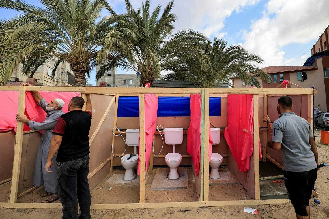 以哈冲突爆发后，加沙地带南部汗尤尼斯的纳赛尔医院（Nasser Hospital）聚集了许多避难的巴勒斯坦人。图为当地人在医院范围内搭建简陋的公厕。（法新社）