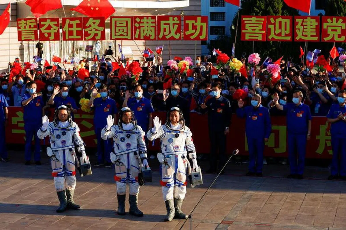 酒泉卫星发射中心今早举行航天员乘组出征仪式，三名航天员挥手致意。（路透社）