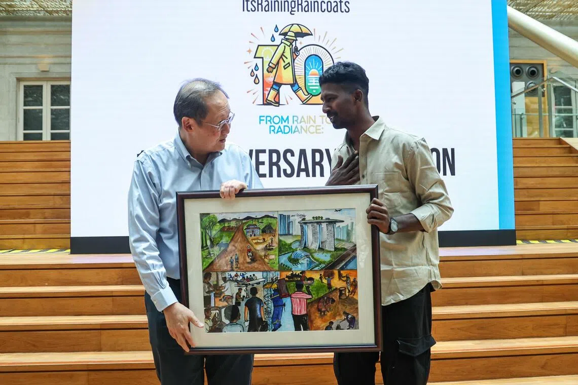 29岁的客工古汗（Guhan Periyasamy）赠送一幅他花了八个多小时完成的水彩画，给人力部长陈诗龙。画中结合他的家乡、父母和新加坡城市景观等多种元素，抒发对家乡的思念和对新加坡的感谢之情。（陈渊庄摄）