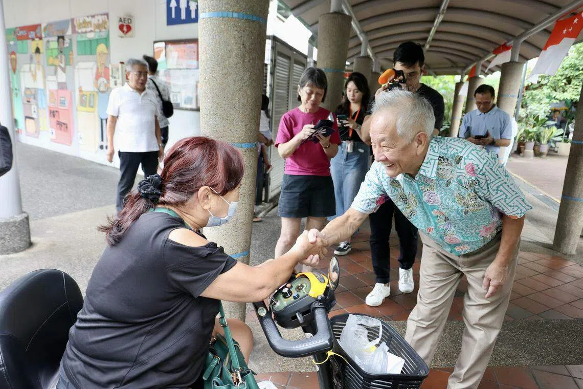 黄国松（前右）走访亚逸拉惹熟食中心。（邝启聪摄）