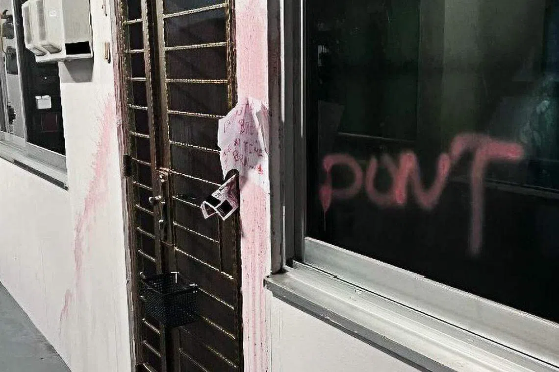 一名20岁男子涉嫌在巴西立第6通道的一个组屋单位外，泼洒掺杂煤油和油漆的液体，还在墙壁贴着写满红字的讨债字条，被警方逮捕。（警方提供）