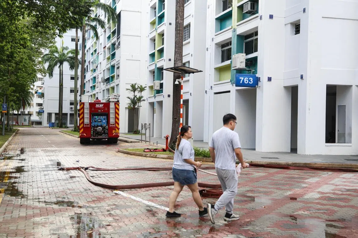 《联合早报》记者早上8时40分许抵达现场时，事发组屋楼下停放了多辆警车和一辆消防车。（关俊威摄）