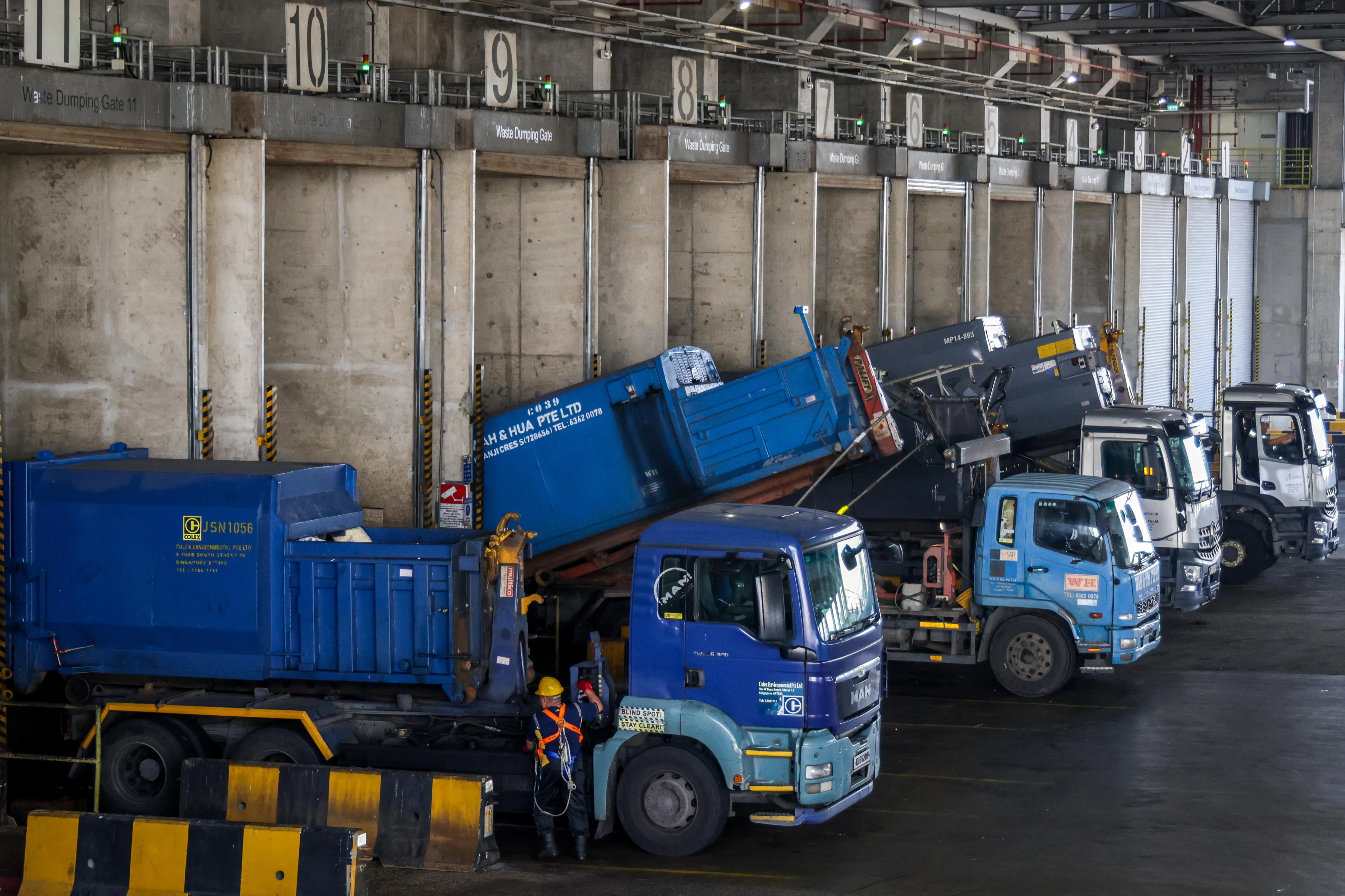 垃圾车井然有序地驶入TuasOne废料转化能源厂，把垃圾倒入垃圾槽。（叶振忠摄）